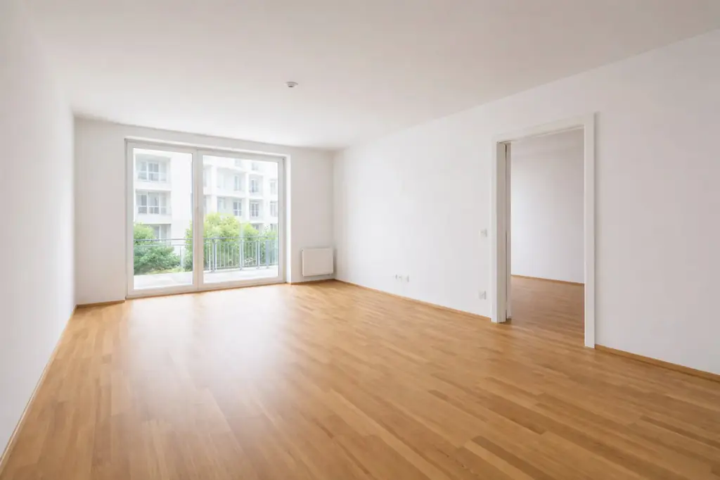 Leeres Wohnzimmer mit Parkett und Balkontür, Originalfoto